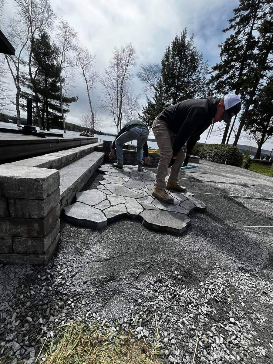 Setting flagstone on a lakefront job